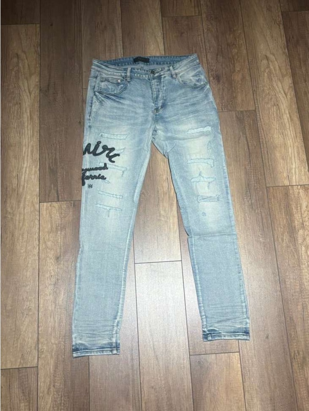 Amiri Mens Light Blue Slim Fit Ripped Jeans with Hollywood California Black Logo